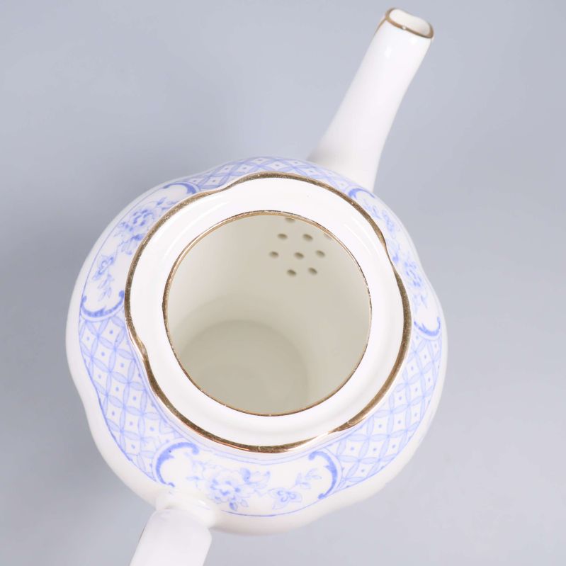 Insidan av blåvit tekanna med gulddetaljer