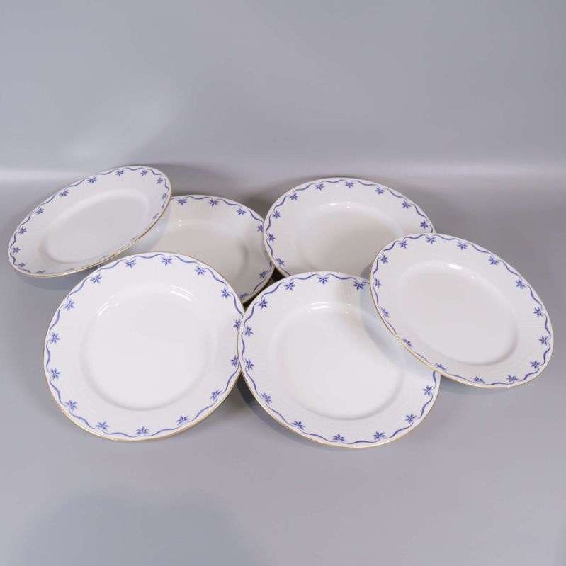 Sex tallrikar med blå dekor och guldkant utlagda
