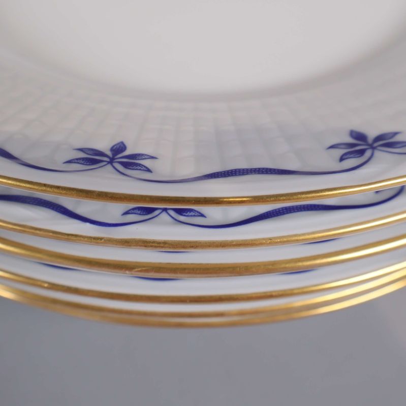 Närbild på guldkant och blå motiv på tallrikar