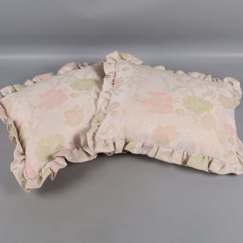 Blommiga kuddar i mjuka pasteller med volanger