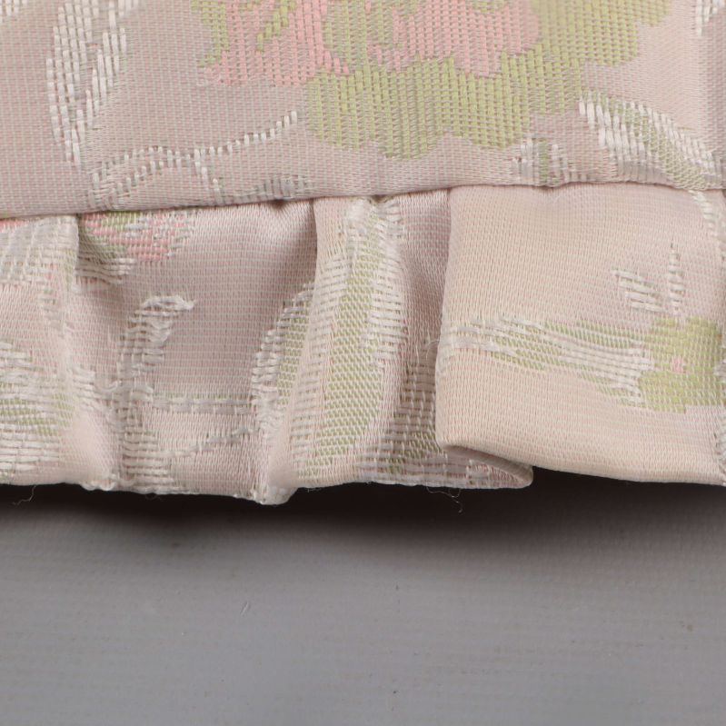 Närbild på volangkant och tygs struktur på kudde