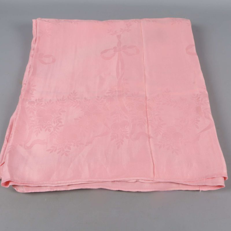 Utbredd rosa duk med vävt blommönster synligt