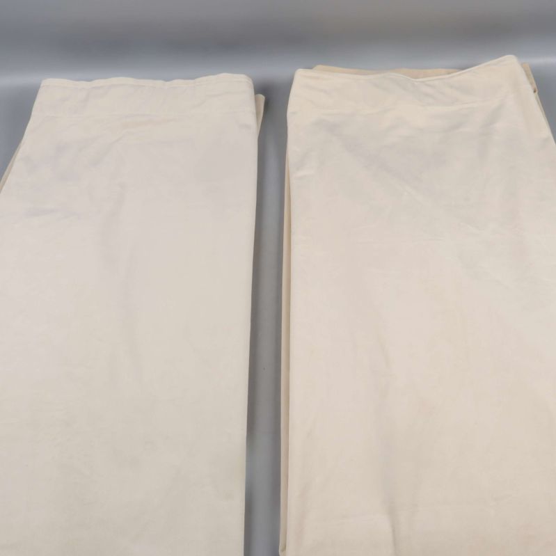 Två utlagda beige gardinlängder på rad