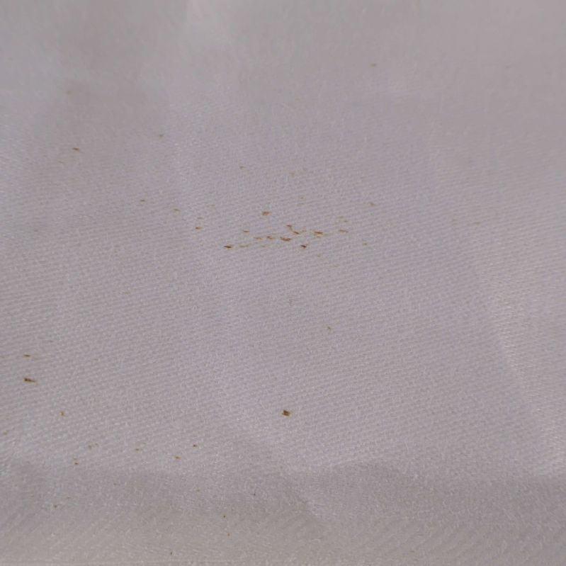 Närbild på vita duken med små fläckar synliga