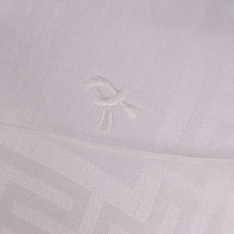 Broderad detalj på vit duk