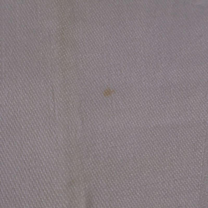 Närbild på mindre fläck på vit duk