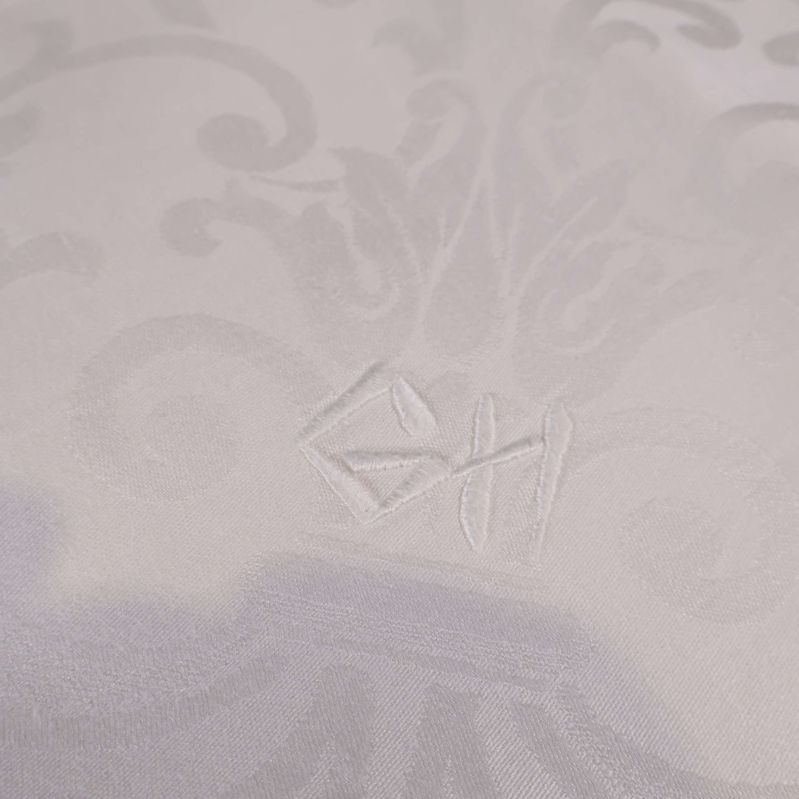 Broderat monogram på vit duk
