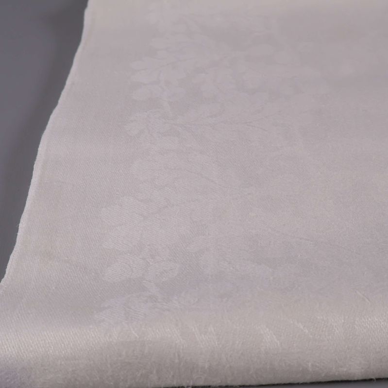 Närbild av ekbladsmönster i vit duk