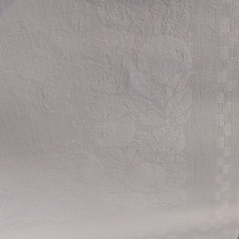 Närbild av vävt blommönster på vit duk