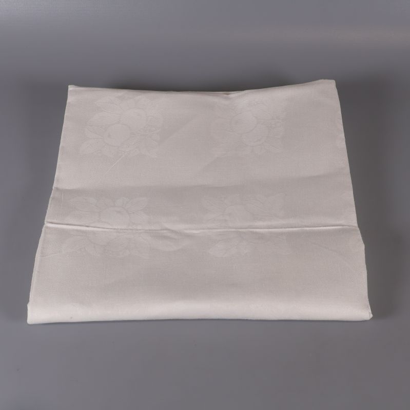 Vikt vit duk i fyrkantig form mot grå bakgrund