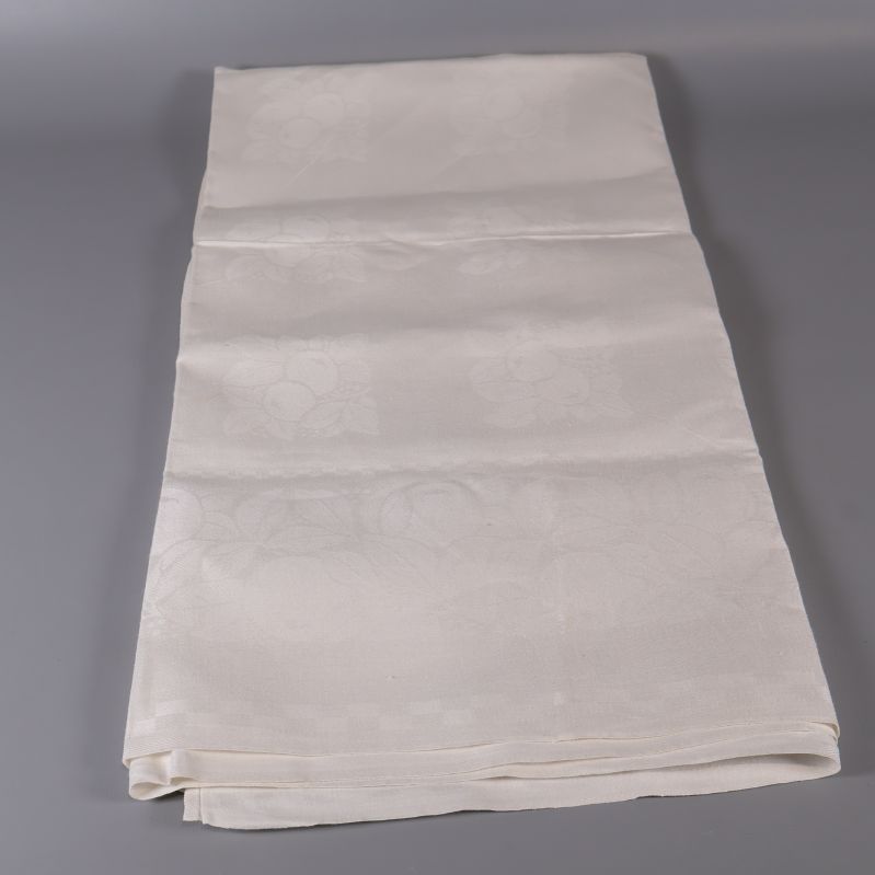 Vit duk utbredd på längden mot grå bakgrund