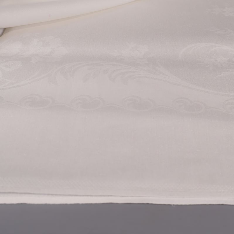 Närbild av dukkant och invävt blommönster