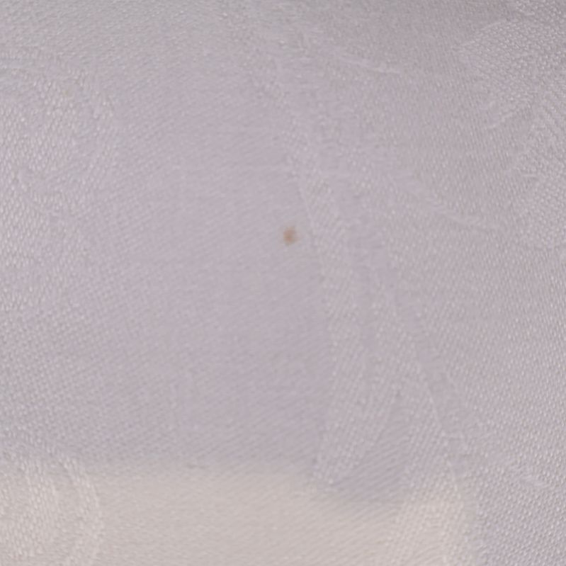 Närbild på liten fläck i duken