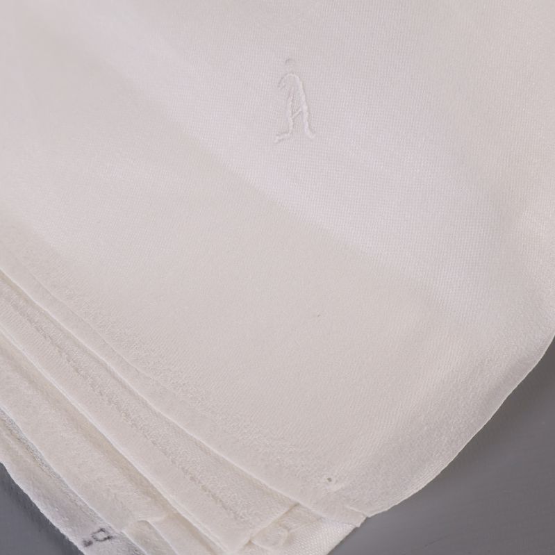 Hörndetalj med broderat litet motiv i duken