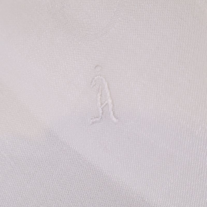 Närbild av broderat motiv i vit duk