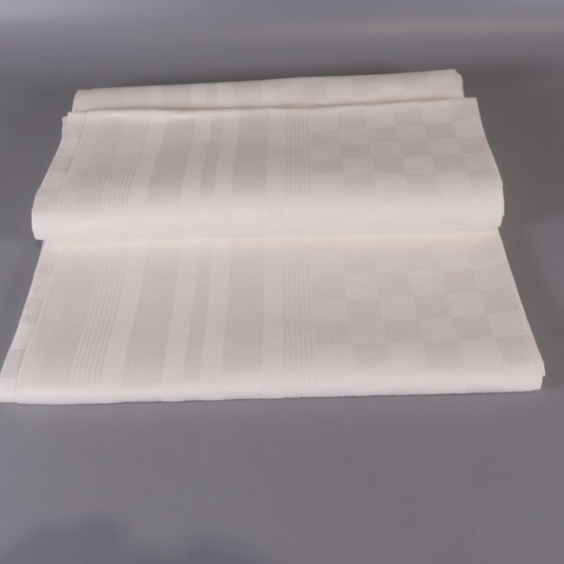 Vikt vit duk med rutigt mönster mot grå bakgrund