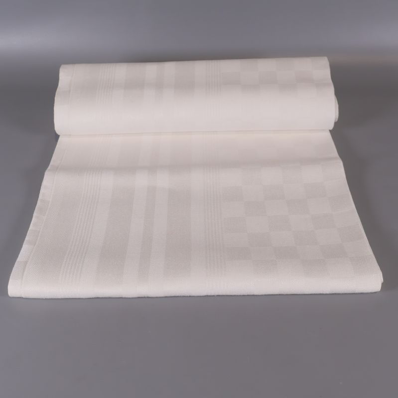 Vit duk utrullad och vikt, rutigt mönster synligt