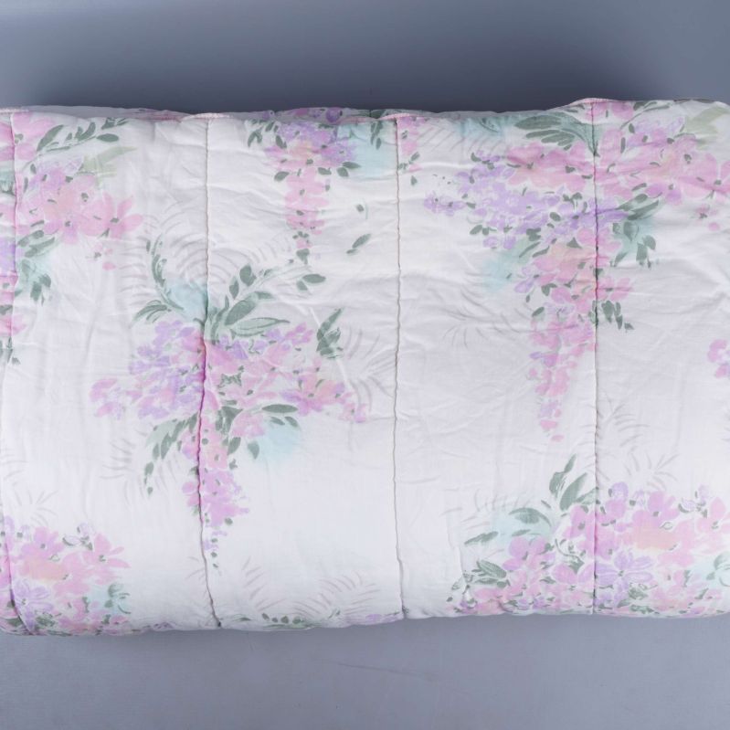 Täcke med blommigt pastellmönster utbrett på golvet