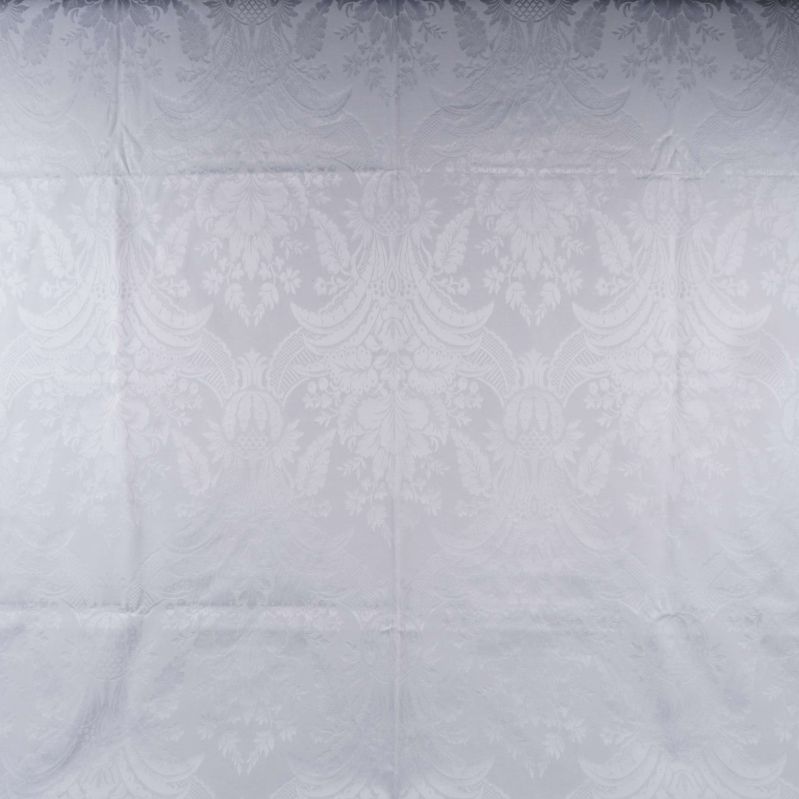 Närbild av vit gardin med blom liknande mönster