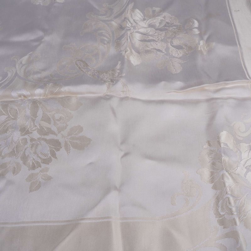 Närbild på dukens glänsande blommönster