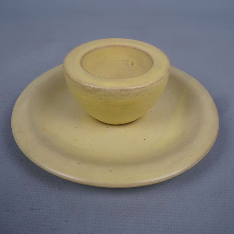 Gul äggkopp placerad på tillhörande fat