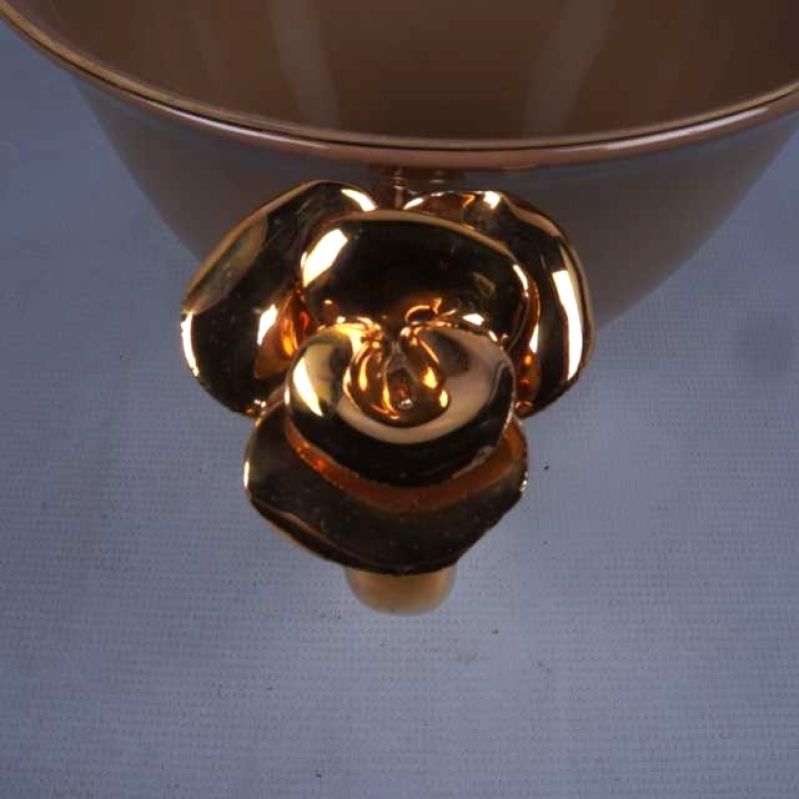 Blomformad dekor på koppens guldfärgade handtag