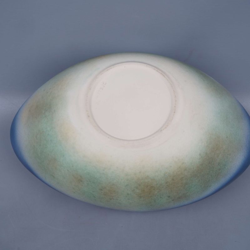 Skålens undersida samt baksida med ljusa och gröna nyanser