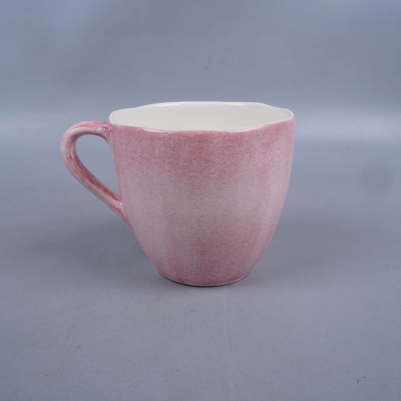 Kopp med rosa utsida och handtag fotograferad från sidan