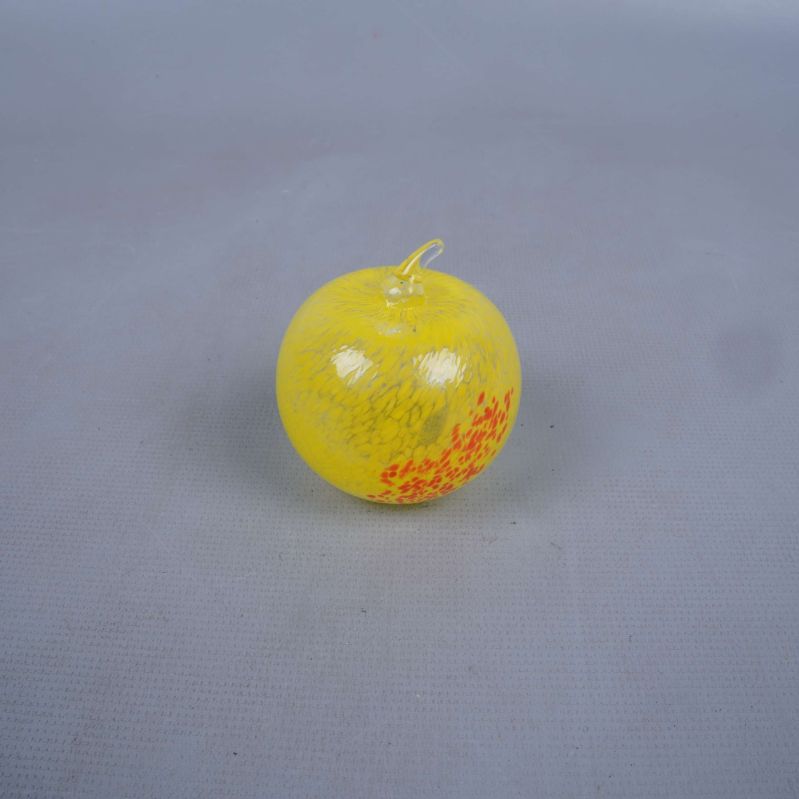 Gult glas äpple med orangea prickar, fotad ovanifrån