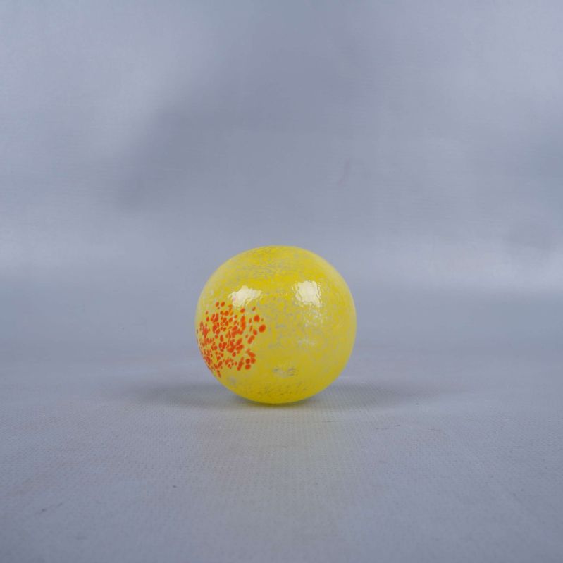 Gult glasäpple med orangea detaljer, sedd underifrån