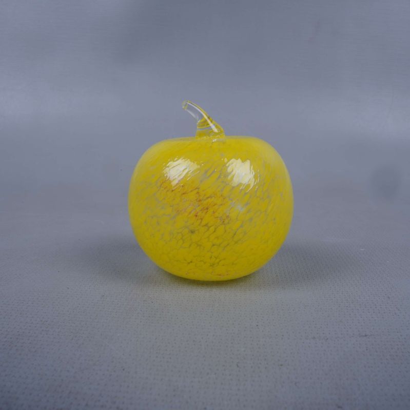 glas figur som är äpple format i gult med stjälk och blanka detaljer