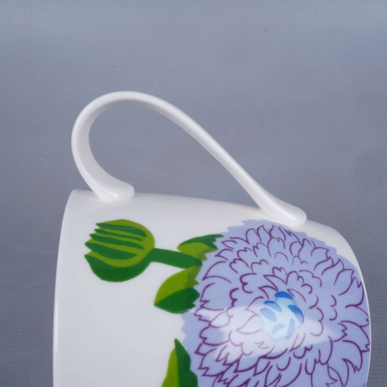 Handtag på kopp med blommönster från sidan