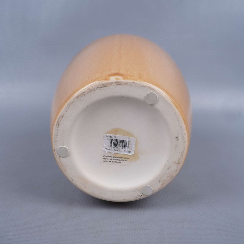 Undersida av vas med produktetikett och tassar