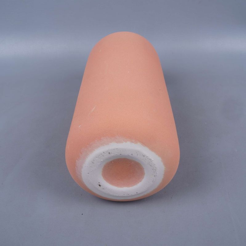 Botten av matt terrakotta färgad vas visas nedifrån