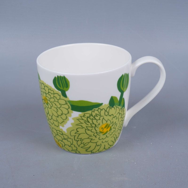 Kopp med grön blomdekor och vitt handtag