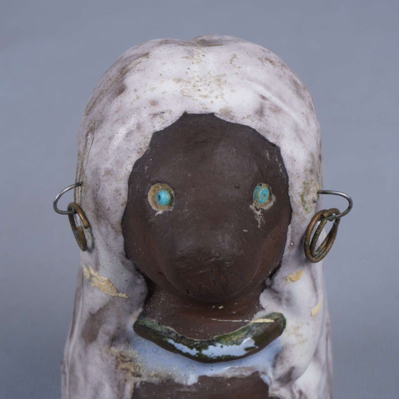 Närbild på figurens ansikte och örhängen