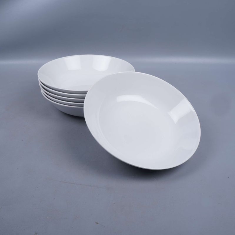 Fem djupa tallrikar staplade, en liggande bredvid