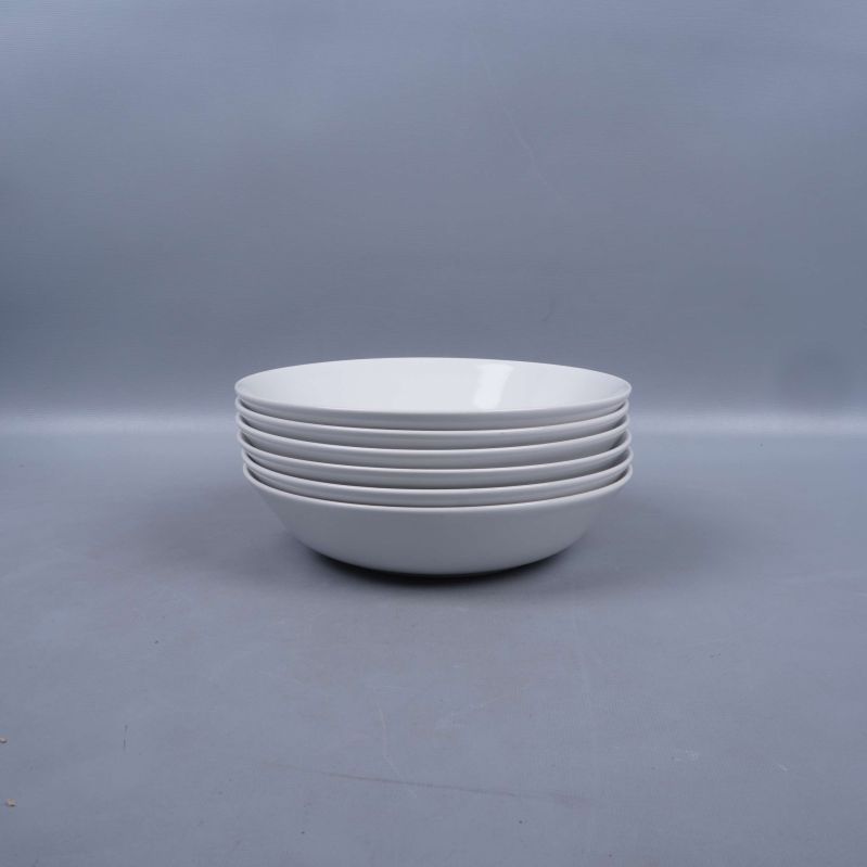 Fem vita djupa tallrikar i stapel från sidan