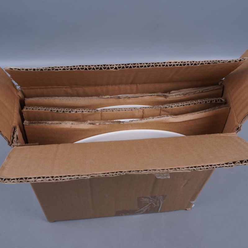 Öppen kartong med fyra vita tallrikar