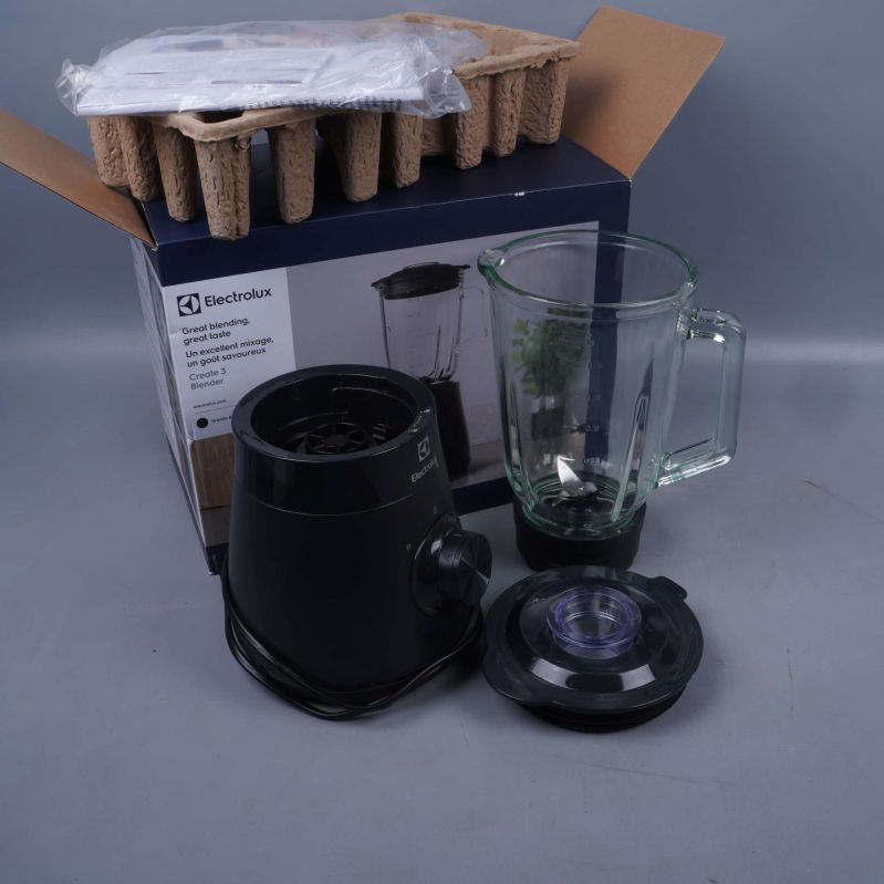 Blender med glaskanna och tillbehör framför originalkartong