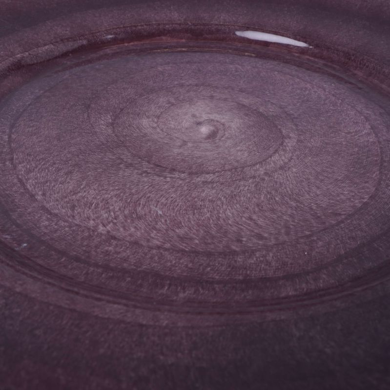 Närbild på tallrikens glaserade lila yta