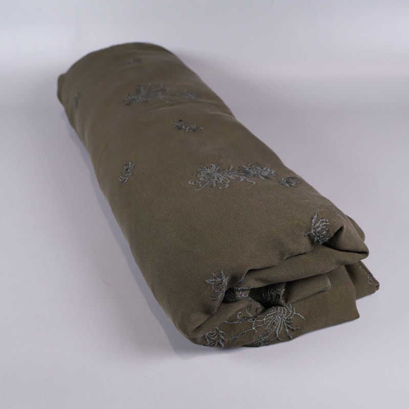 Tyg rullat i en cylinderform med blommigt broderi