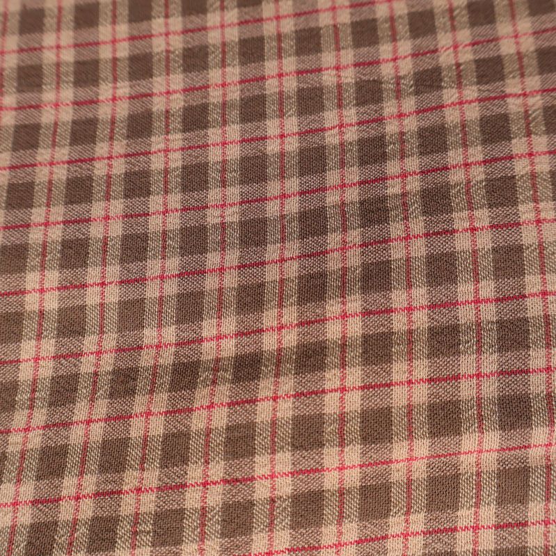 Närbild på rutigt mönster i beige och brunt tyg