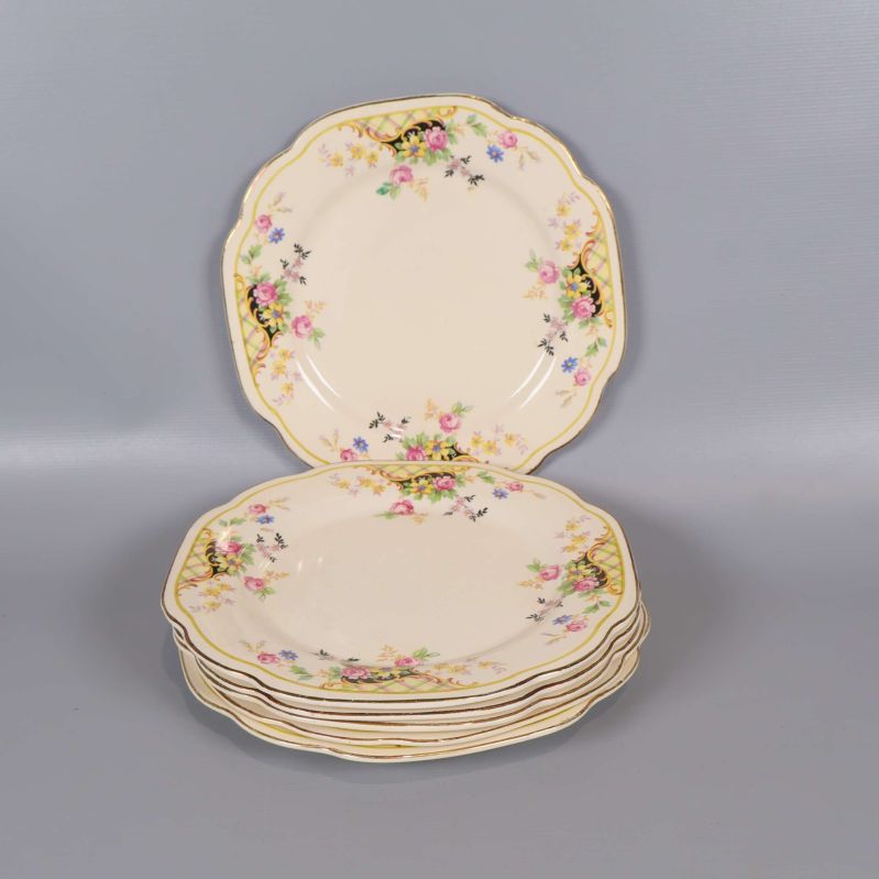 Sex staplade assietter med blommönster och vågig kant