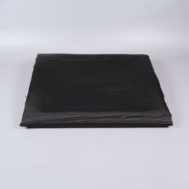 Vikta svarta tygbitar mot ljus bakgrund