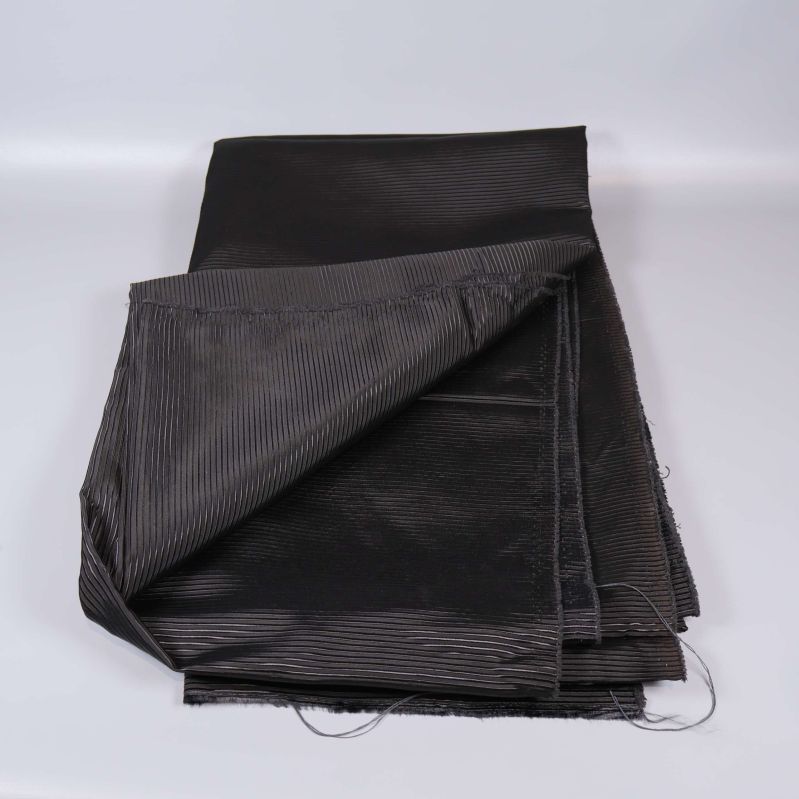 Uppvikta svart tygstycken med ribbad yta synlig