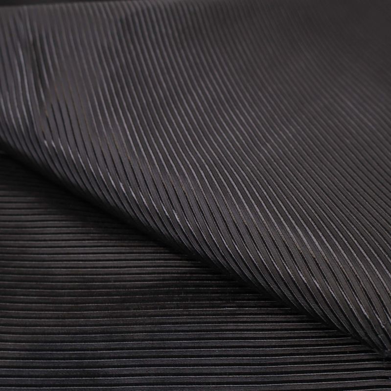 Närbild av ribbad och glansig svart tygtextur