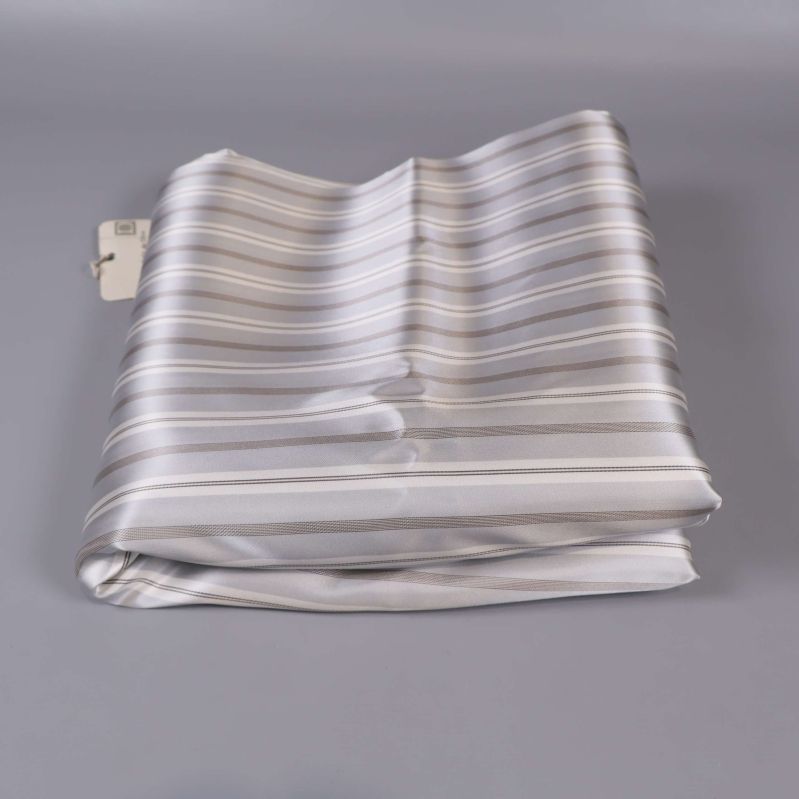 Randigt satin de chine tyg snyggt vikt på bordet