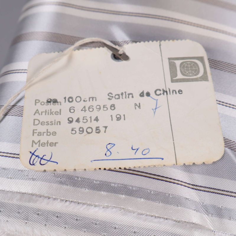 Närbild på etikett med text om satin de chine tyg