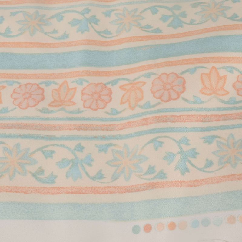 Närbild av tygmönster med blommor och prickar